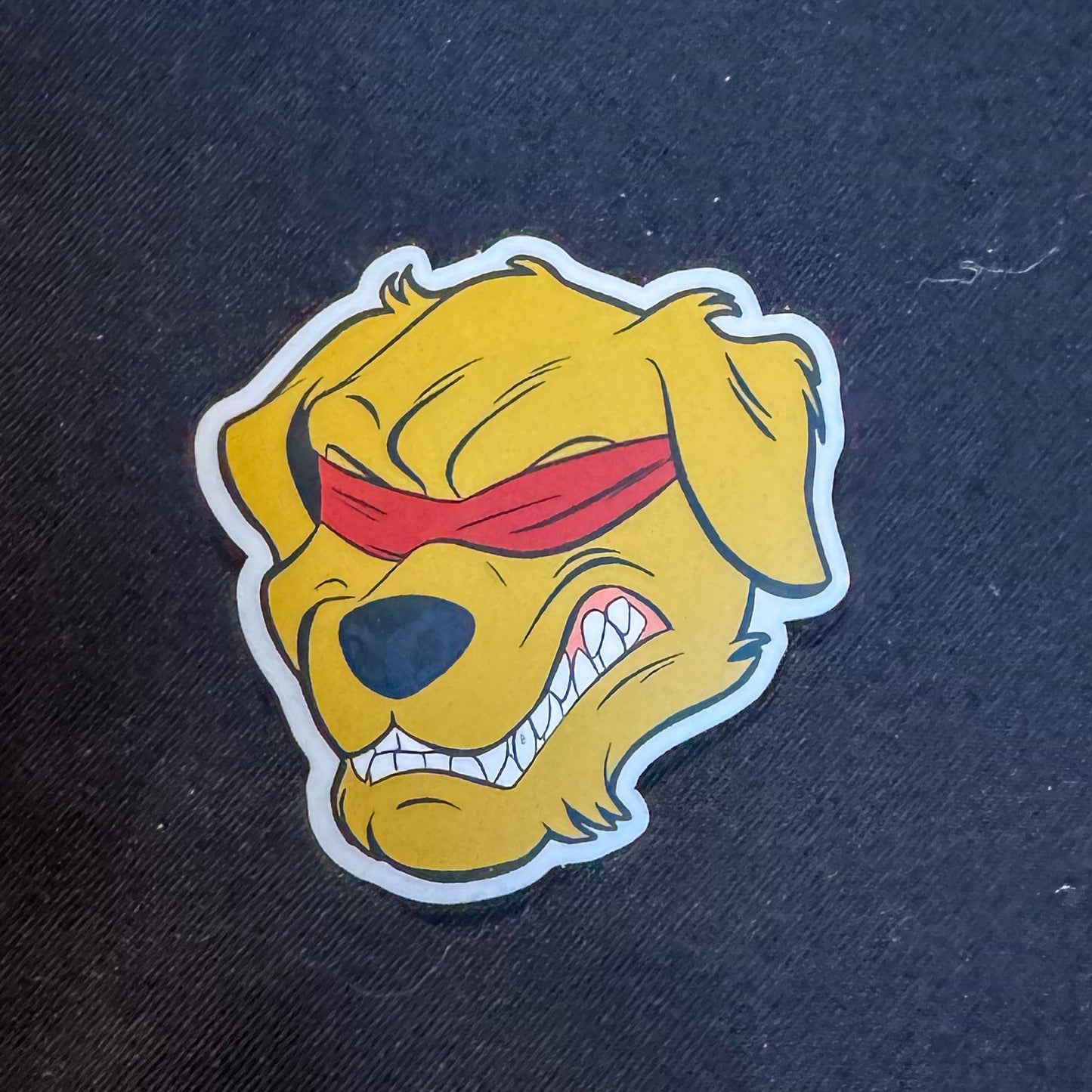 The image shows a sticker of the Halo Fight Gear Icon Sticker on a black background. The sticker features the Halo Fight Gear logo, a fierce golden retriever with bared teeth, wearing a red blindfold. The image shows a sticker of the Halo Fight Gear Icon Sticker on a black background. The sticker features the Halo Fight Gear logo, a fierce golden retriever with bared teeth, wearing a red blindfold.